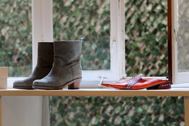 A pair of boots and red shoes on a windowsill