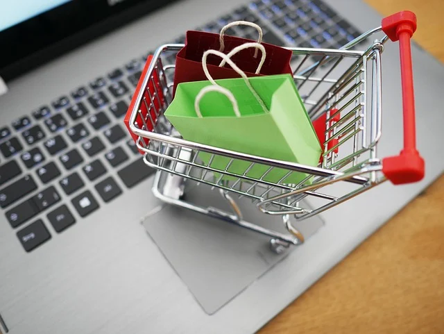 A miniature shopping cart on a laptop keyboard