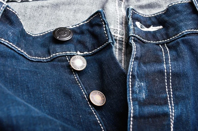 Close-up of dark denim waistband and button fly details