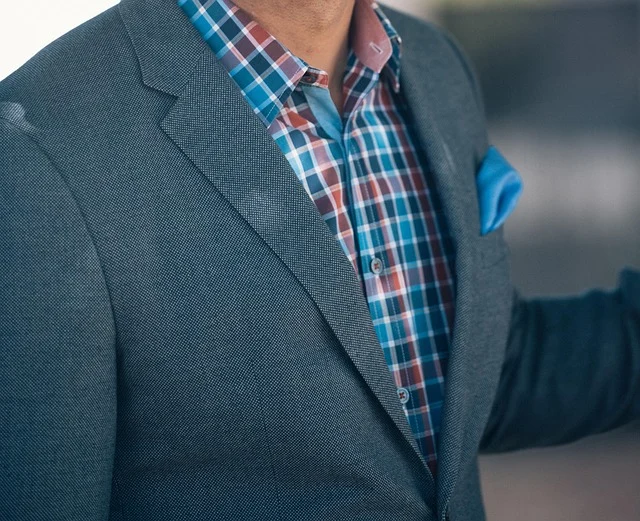 Close-up of a blazer worn over a plaid shirt