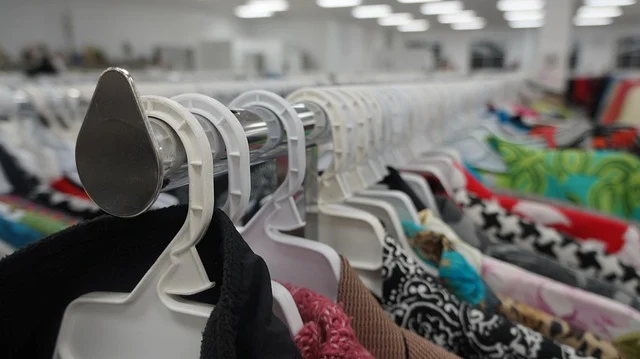 Clothes hanging on plastic hangers on a rack in a store