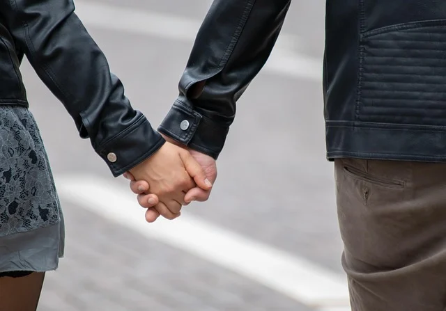 A couple holding hands while both wearing black leather jackets