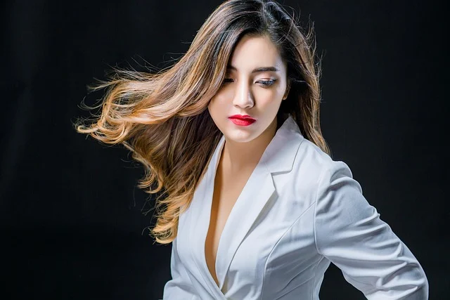 A woman with flowing hair wearing a white blazer