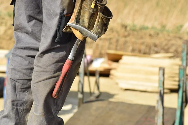 A construction worker wearing a heavy-duty tool belt with tools