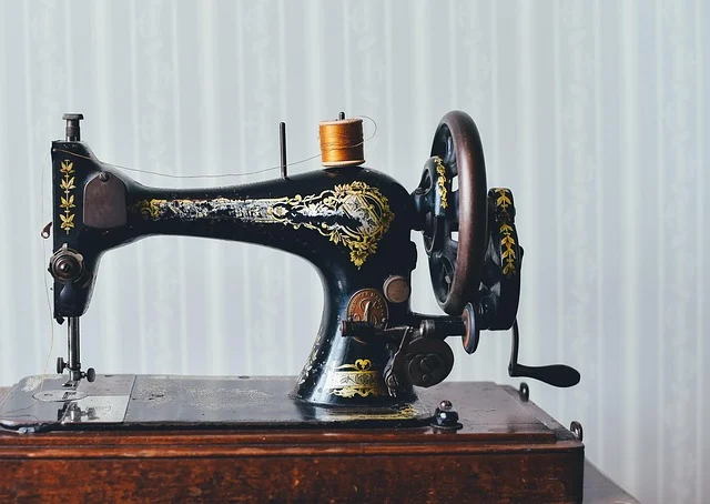 A vintage black sewing machine with thread