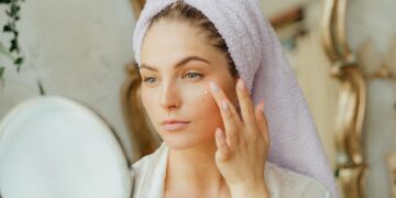 woman applying face serum