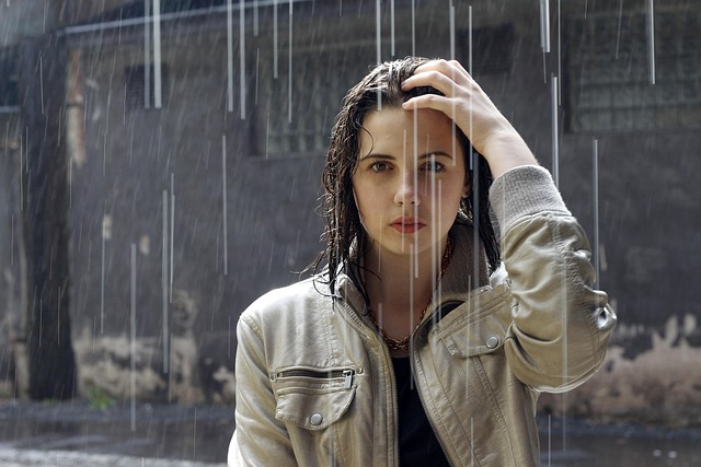 A woman looking confused at a pile of clothes, representing outfit indecision.