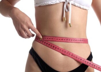 woman measuring waist for belt