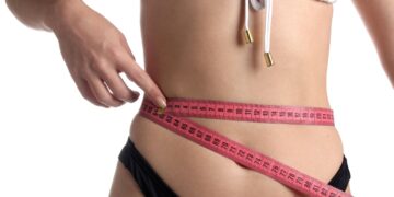 woman measuring waist for belt