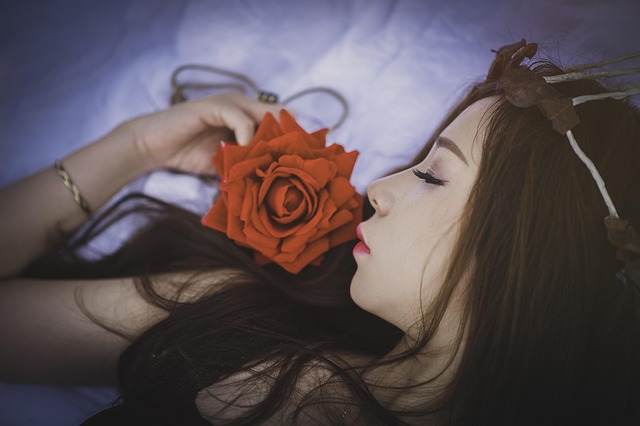 Woman sleeping on a silk pillowcase with her curly hair neatly arranged.