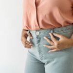 woman tucking shirt into jeans
