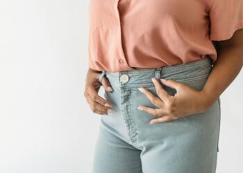 woman tucking shirt into jeans