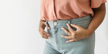 woman tucking shirt into jeans