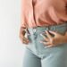 woman tucking shirt into jeans