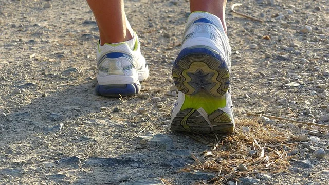 Close-up view of a person running in athletic shoes on a path
