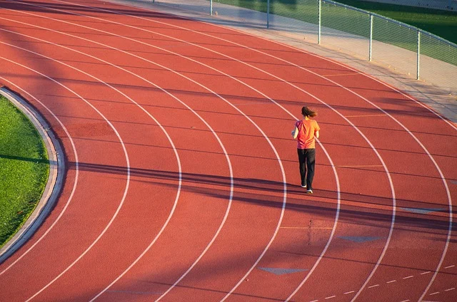 A person running on a red athletic track