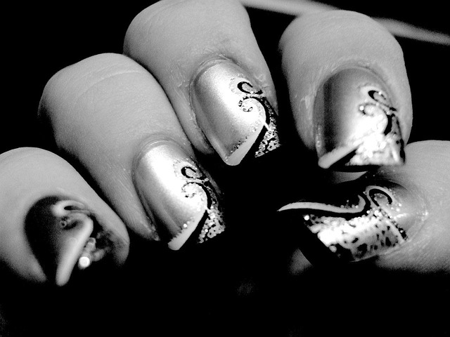 Black nails with scattered gold foil accents.