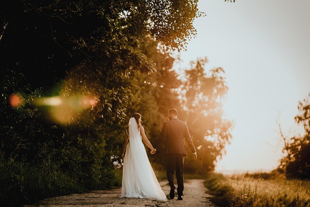 Bride being laced into a corset wedding dress by a seamstress