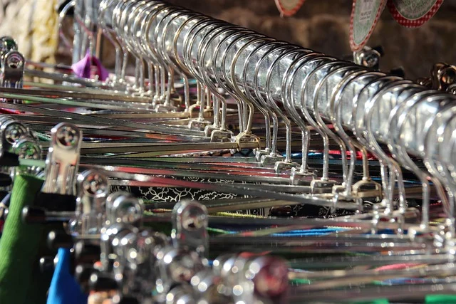 A row of metal clothes hangers on a clothing rack