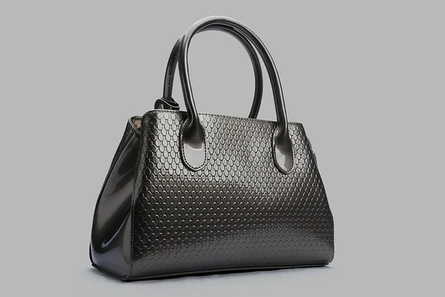 A glossy dark grey textured women's handbag with handles