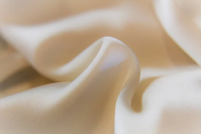 Scarf top: Close up of smooth draped beige silk fabric