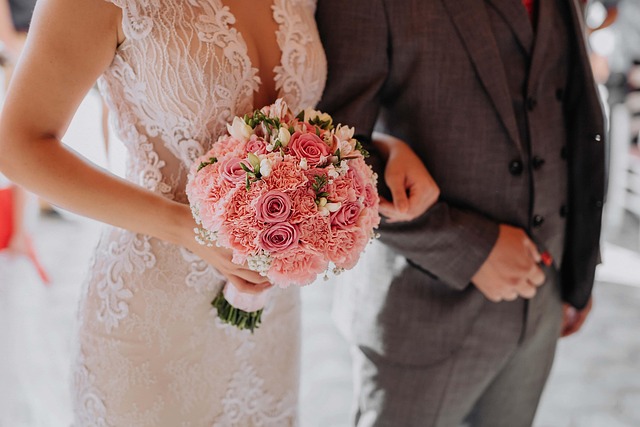 Close-up of a bride's hand touching a luxurious silk crepe fabric used in a modern wedding dress.