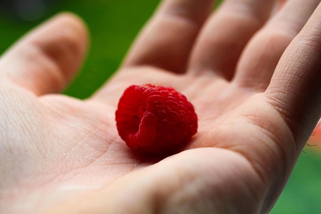 Close-up of a hand gently peeling a decorative nipple cover from skin, showing the adhesive.