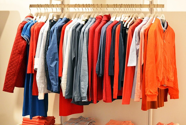 Clothing store owner examining racks of garments, with financial charts overlaid (inventory financing for clothing business)