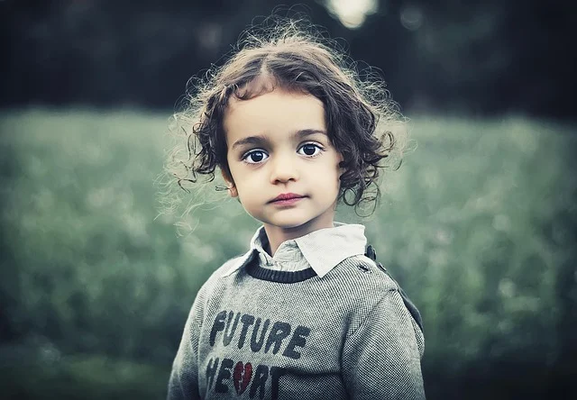 A young child with curly hair outdoors