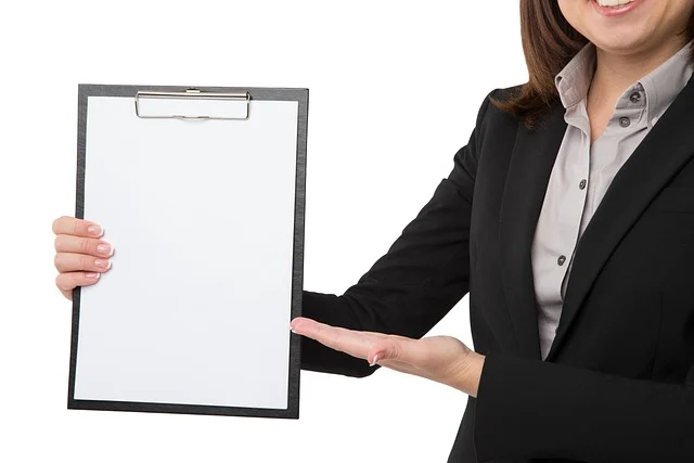 A woman in a suit holding a blank clipboard