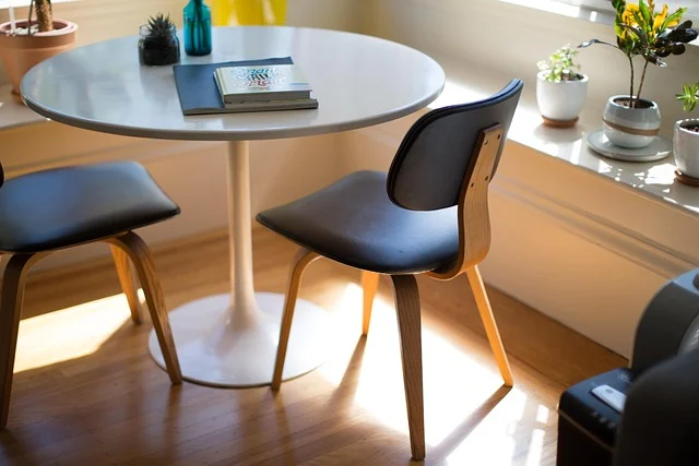 A round white table with two chairs and potted plants