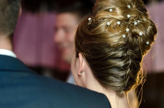 The back of a woman's head featuring an elegant French twist updo with pearl pins