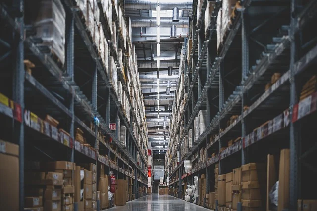 A large warehouse aisle filled with high shelves of boxed inventory