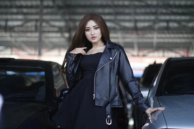 A woman wearing a black dress and leather jacket