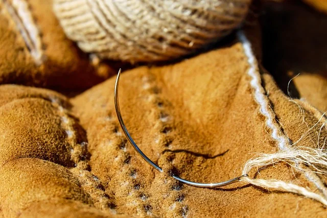 A curved needle stitching suede leather material with thread