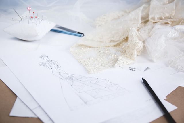 A fashion design sketch with lace fabric and sewing tools