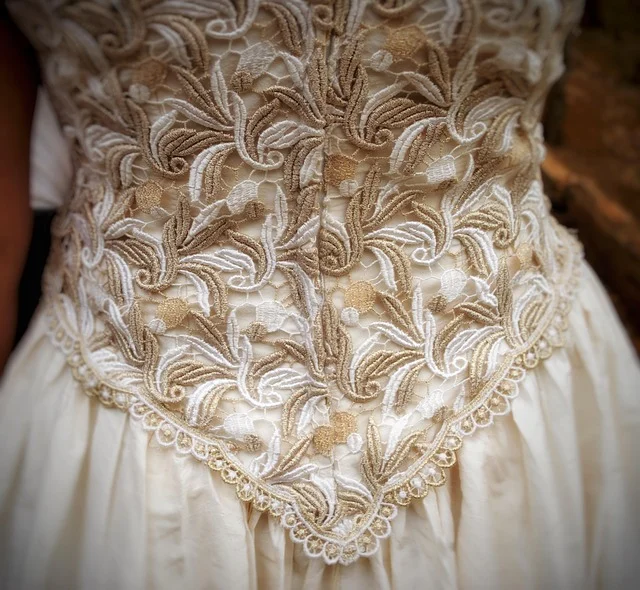 Close up of intricate embroidery and lace on a gown corset bodice