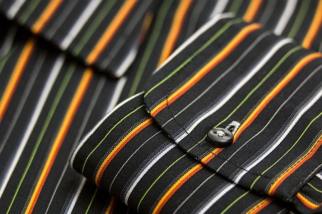 Close up of a striped dress shirt with cuff and button