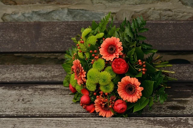 A colorful bouquet of cut flowers resting on a wooden bench