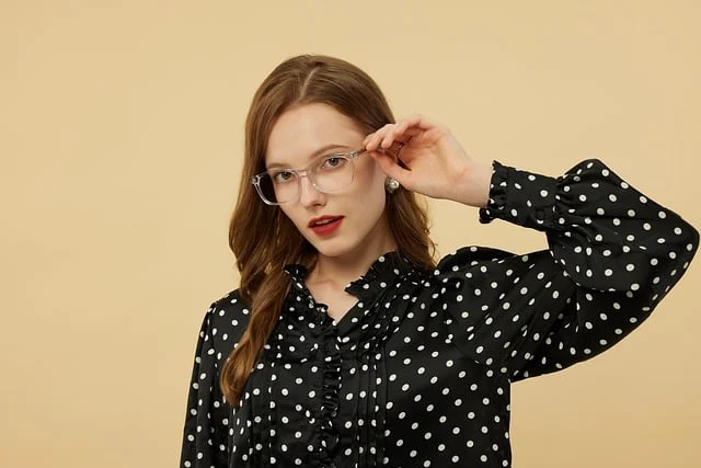 A woman wearing glasses and a black polka dot blouse