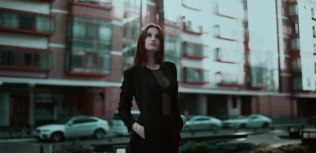A woman in a stylish black blazer standing outdoors