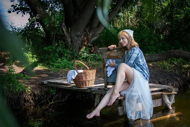 A woman washing clothes using an old-fashioned washboard outdoors