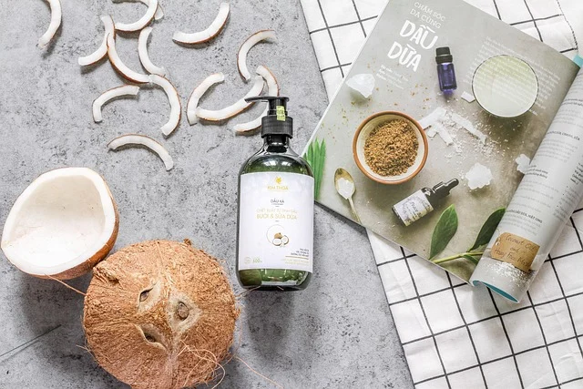 Coconuts, coconut slices, and hair care oil bottle flat lay