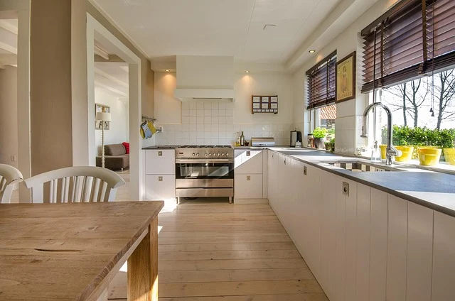 A bright kitchen with white cabinets and dark countertops