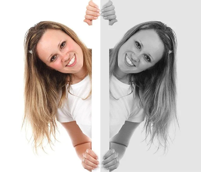 A woman peeking from behind a wall in color and grayscale
