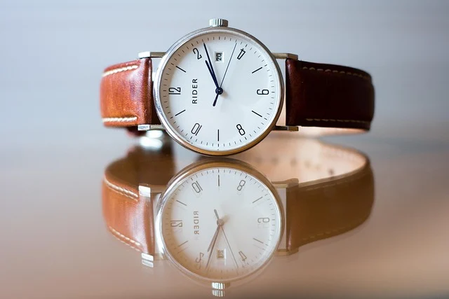 Luxury watch insurance: A wristwatch with a brown leather strap resting on a reflective surface