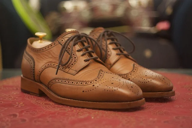 A pair of brown leather brogue shoes with shoe trees inside