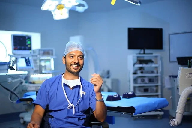 A patient smiling confidently in a dental chair after cosmetic dental work, with a dentist observing. (cosmetic dentist near me)