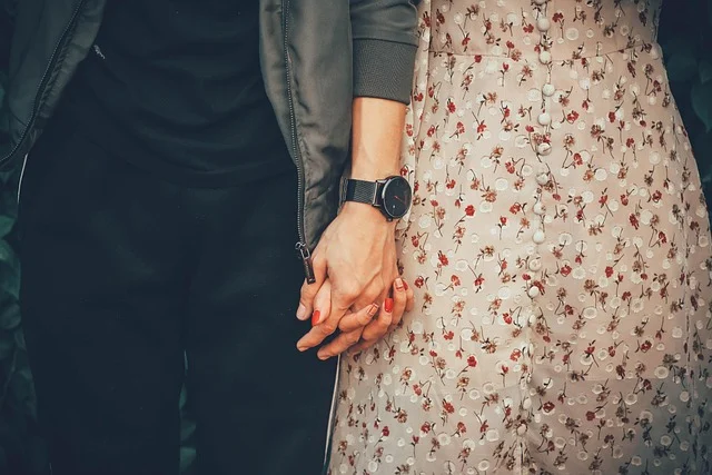 A couple holding hands while wearing stylish clothing