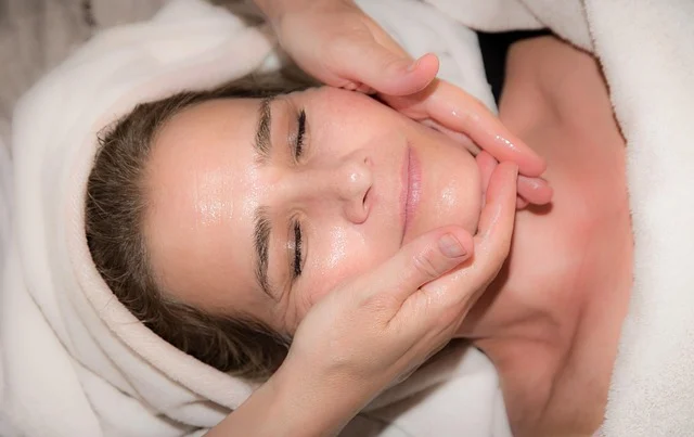 Hands applying product or massage to a woman's face during skincare